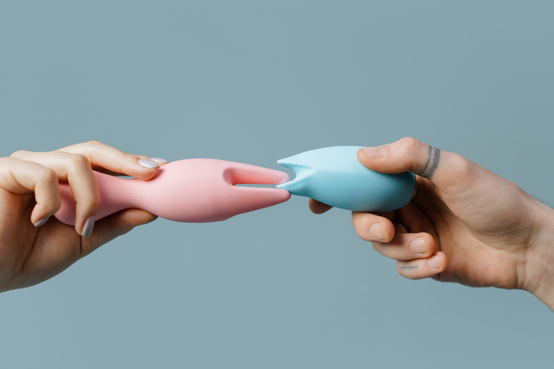 Hand holding a modern vibrator against a purple backdrop, symbolizing reconnection and self-care