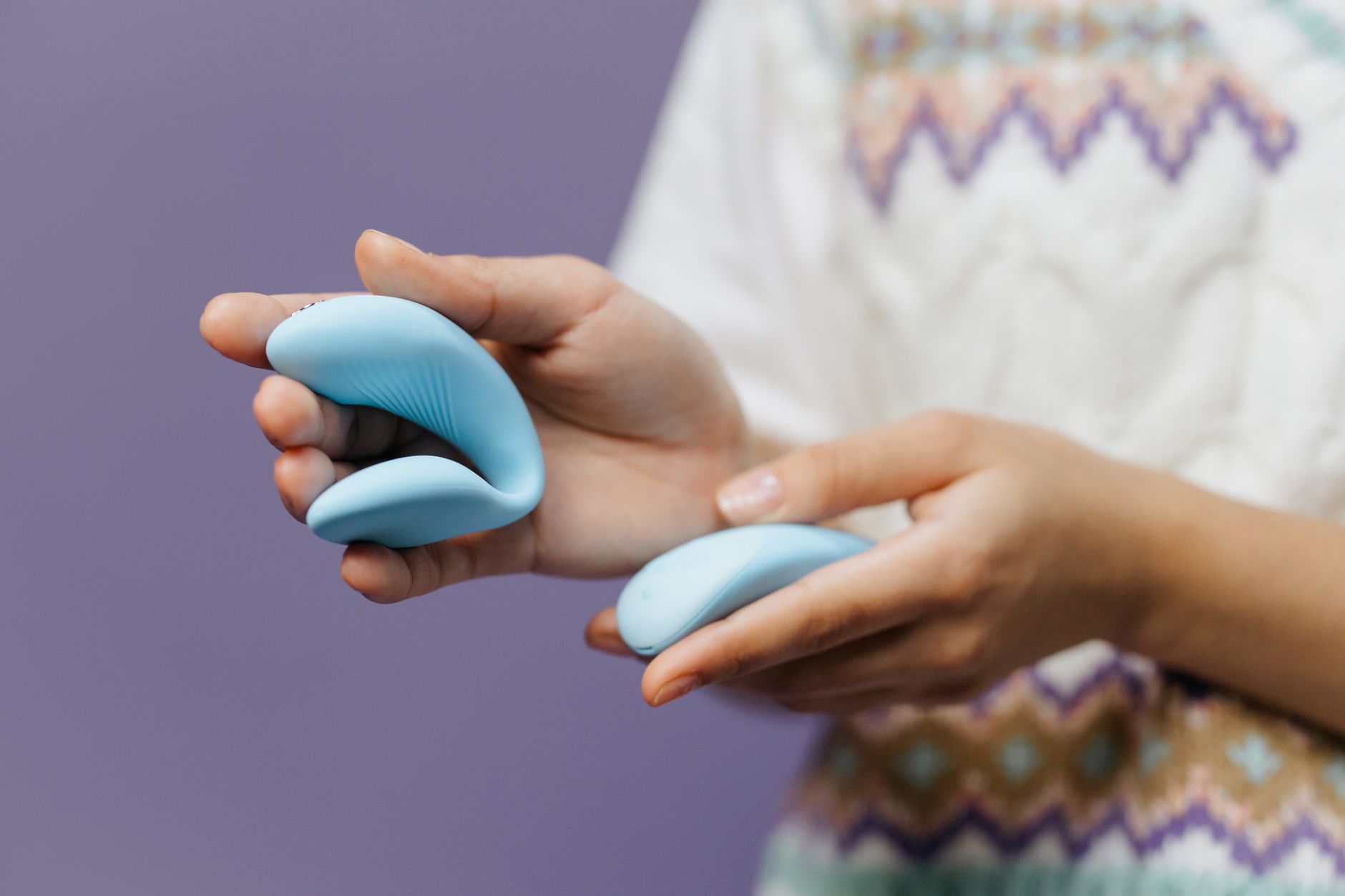 Close-up of hands holding a sleek vibrator, representing returning to pleasure and sexual wellness after medication side effects.