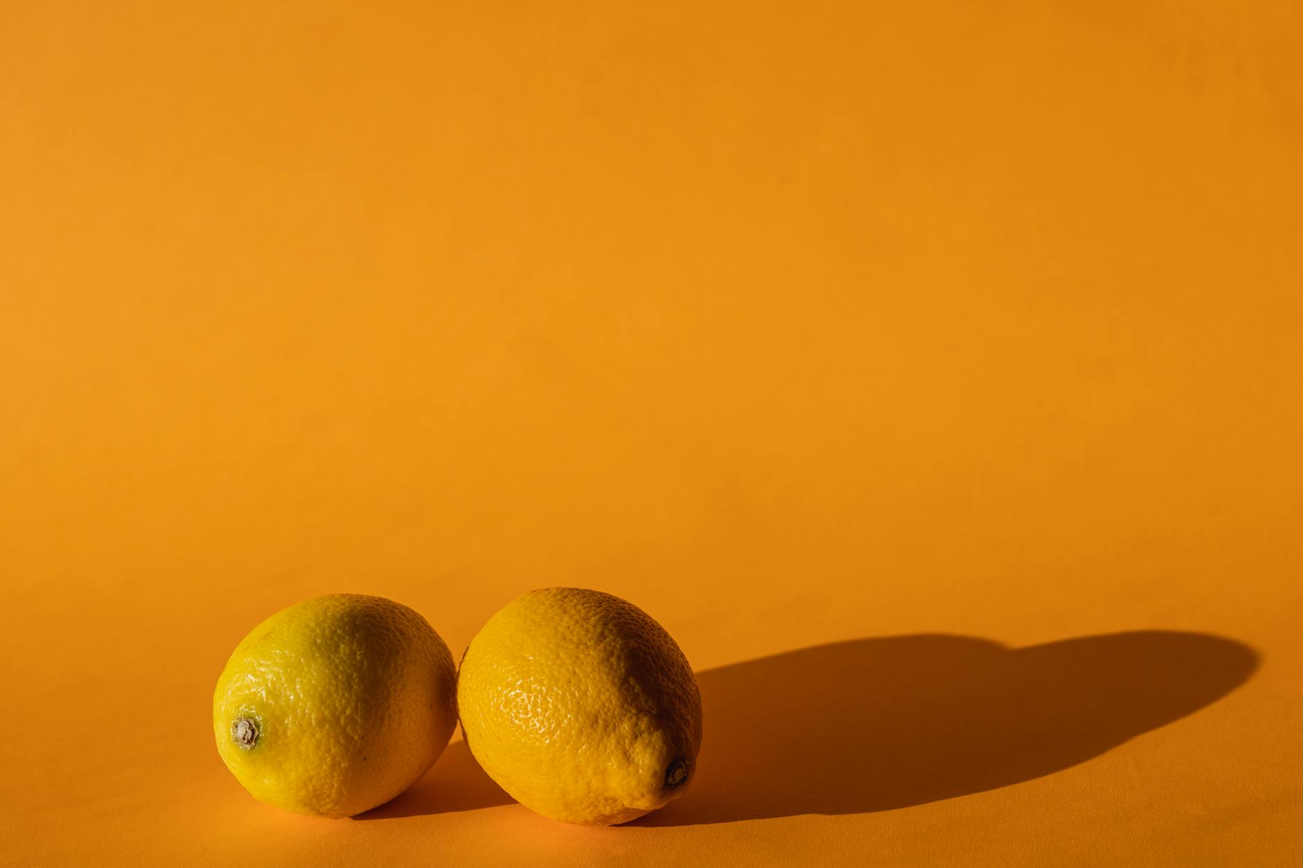 Ripe vivid lemons on a bright yellow background, symbolizing freshness and renewal